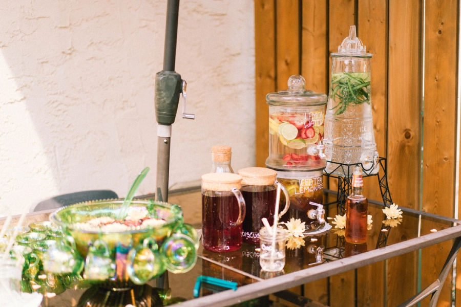 Selbstgemachter Eistee mit frischem Obst und geschnittenen Beeren im Wasser für einen heißen Sommertag zum Genießen