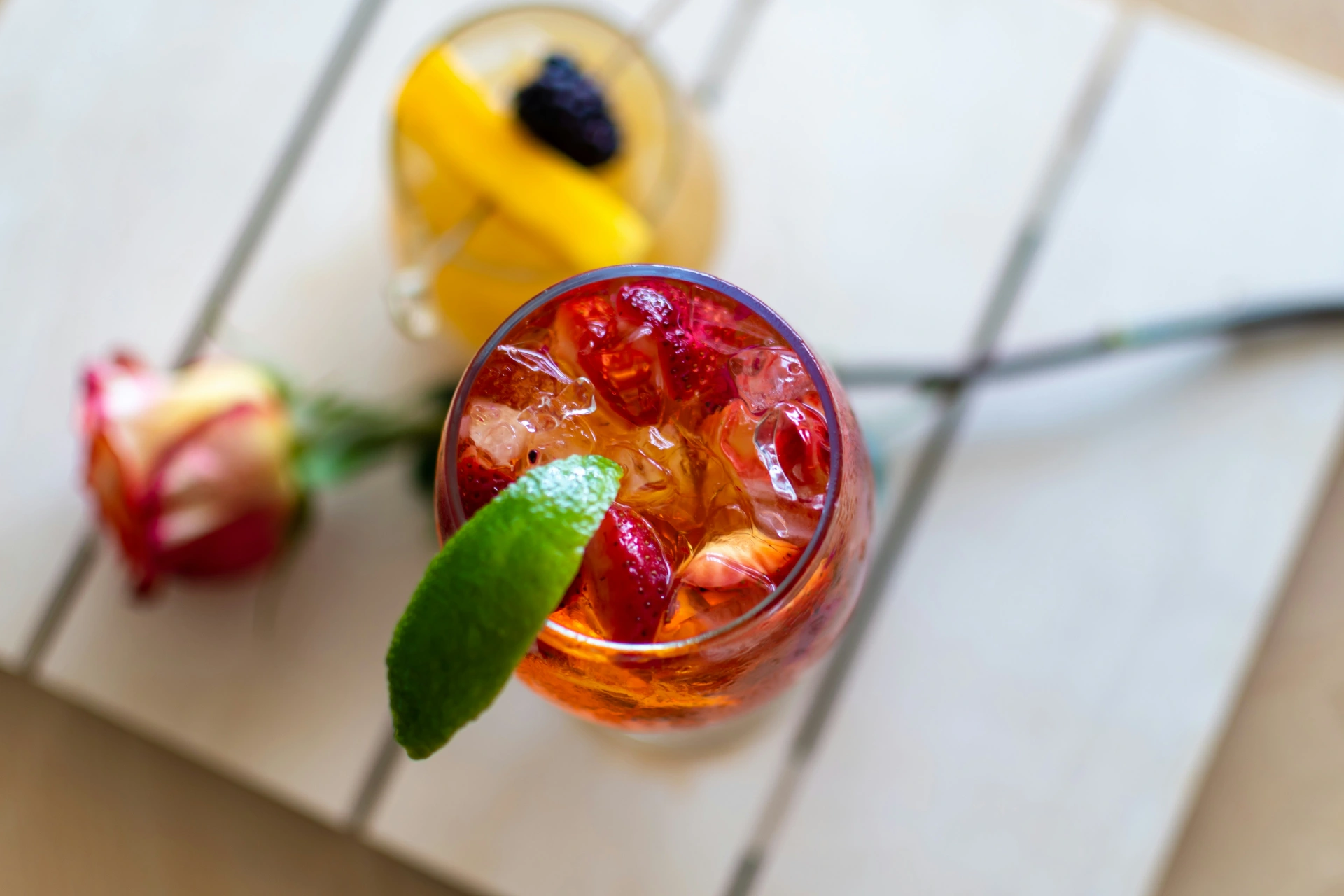 Eistee in einem Glas angerichtet mit Erdbeeren und Limette
