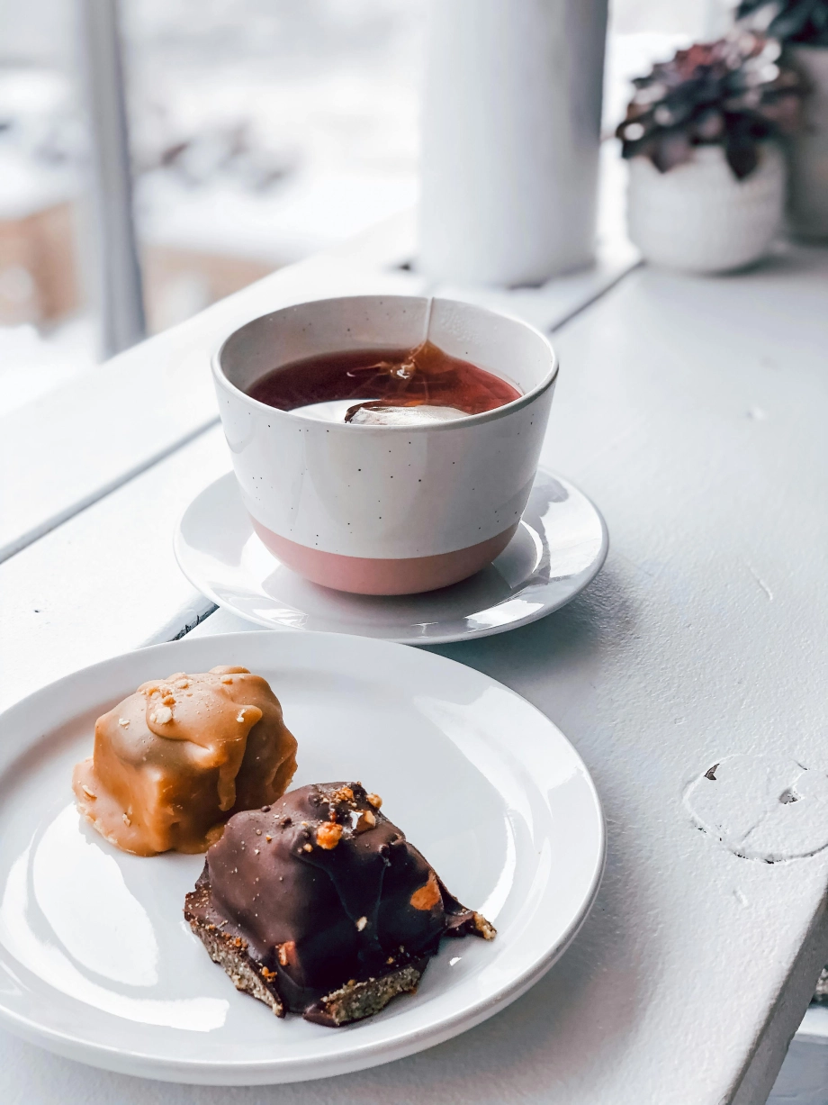 Teetasse mit Schlürf Tee und zwei Karamell Schokoladen Kuchenstücken
