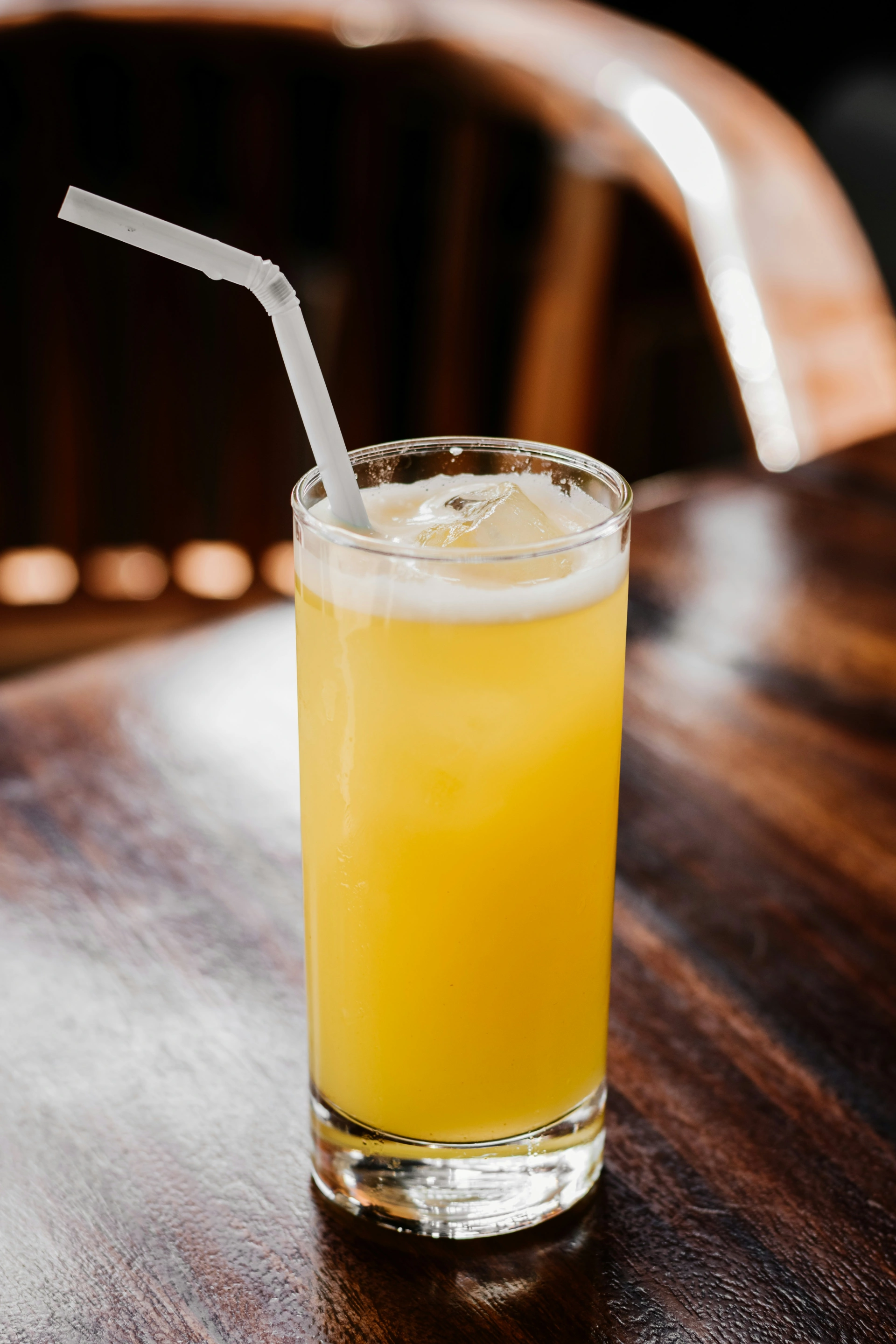 Eistee mit Maracuja-Saft in einem hohen Glas mit Strohhalm als Erfrischung im Sommer