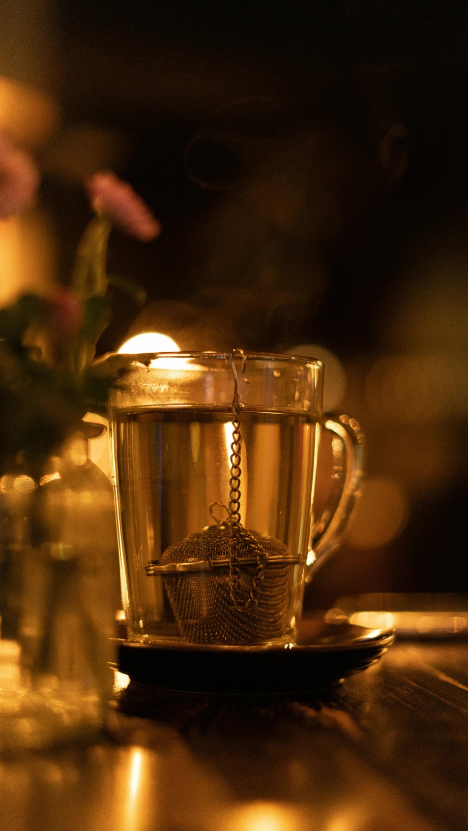 Teetasse aus Glas bei Kerzenlicht. Entspannte Abendstimmung